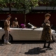 a woman standing next to a white convertible car