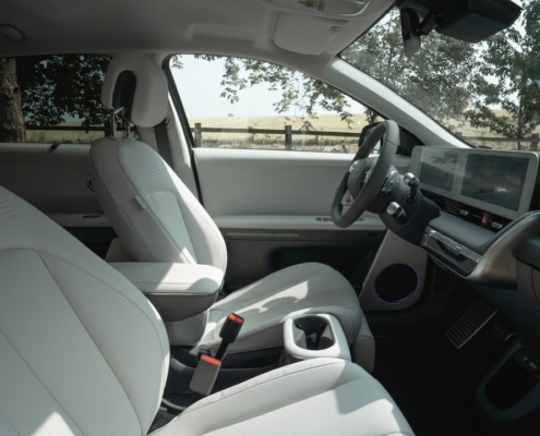 Interior view of a modern car with white seats.
