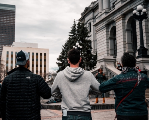 man in gray sweater standing in front of man in black jacket