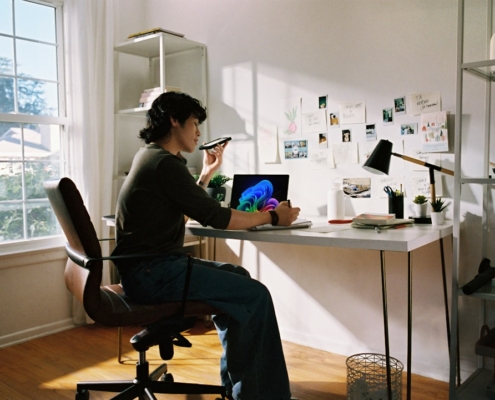 Person working at desk with laptop and phone.