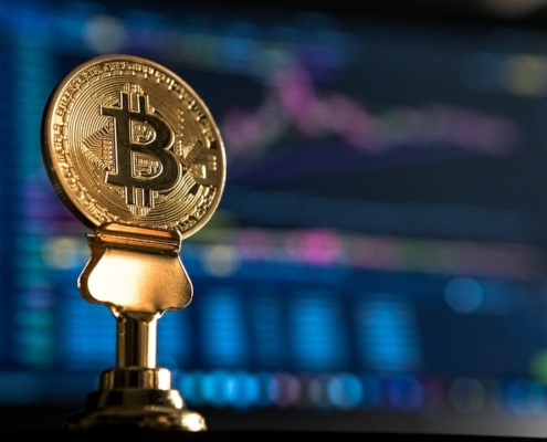 selective focus photo of Bitcoin near monitor