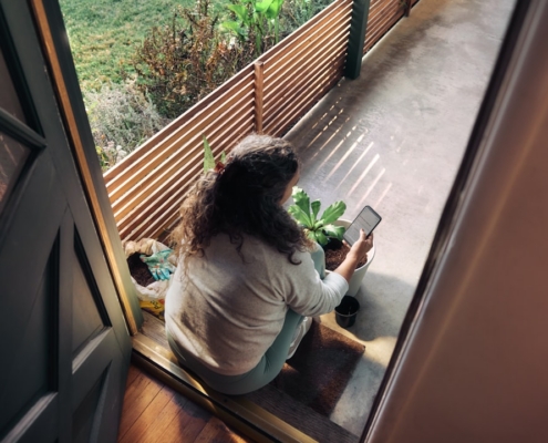 Woman sitting on balcony with smartphone