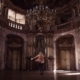 woman standing under gold chandelier indoors